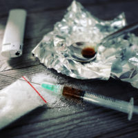 Drug addiction, syringe and cooked heroin on spoon Drug addiction, syringe and cooked heroin on spoon