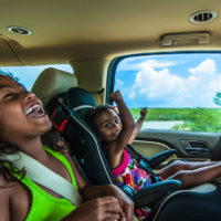 Brazilian girls singing and laughing sitting in backseat in car