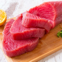 Raw tuna steak on wooden cutboard Raw tuna steak on wooden cutboard