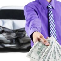 Man with broken car shows dollar money