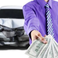 Man with broken car shows dollar money Man with broken car shows dollar money