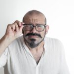 Caucasian man with moustache and glasses with vision impairment,