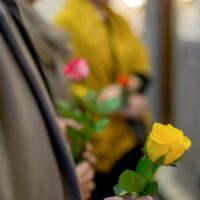 Image of people holding single roses at a funeral, representing the loss of a loved one and how the WV wrongful death attorneys at Burke, Schultz, Harman & Jenkinson can help if your loved one’s death was due to someone else’s fault or negligence.