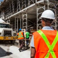 Image of a construction worker onsite with a neon safety vest, representing how a WV construction accident attorney at Burke, Schultz, Harman & Jenkinson can help with workers’ compensation claims and liability lawsuits.