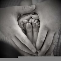 Image of baby’s feet and parents’ hands, representing how a West Virginia birth injury attorney helps families recover.