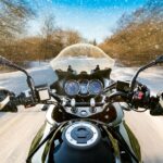 Biker rides on winter slippery road. First-person view.