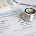 Plan for medical expenses concept. Medical treatment expense on bill statement with calculator and stathoscope. Plan for medical expenses concept. Medical treatment expense on bill statement with calculator and stathoscope.